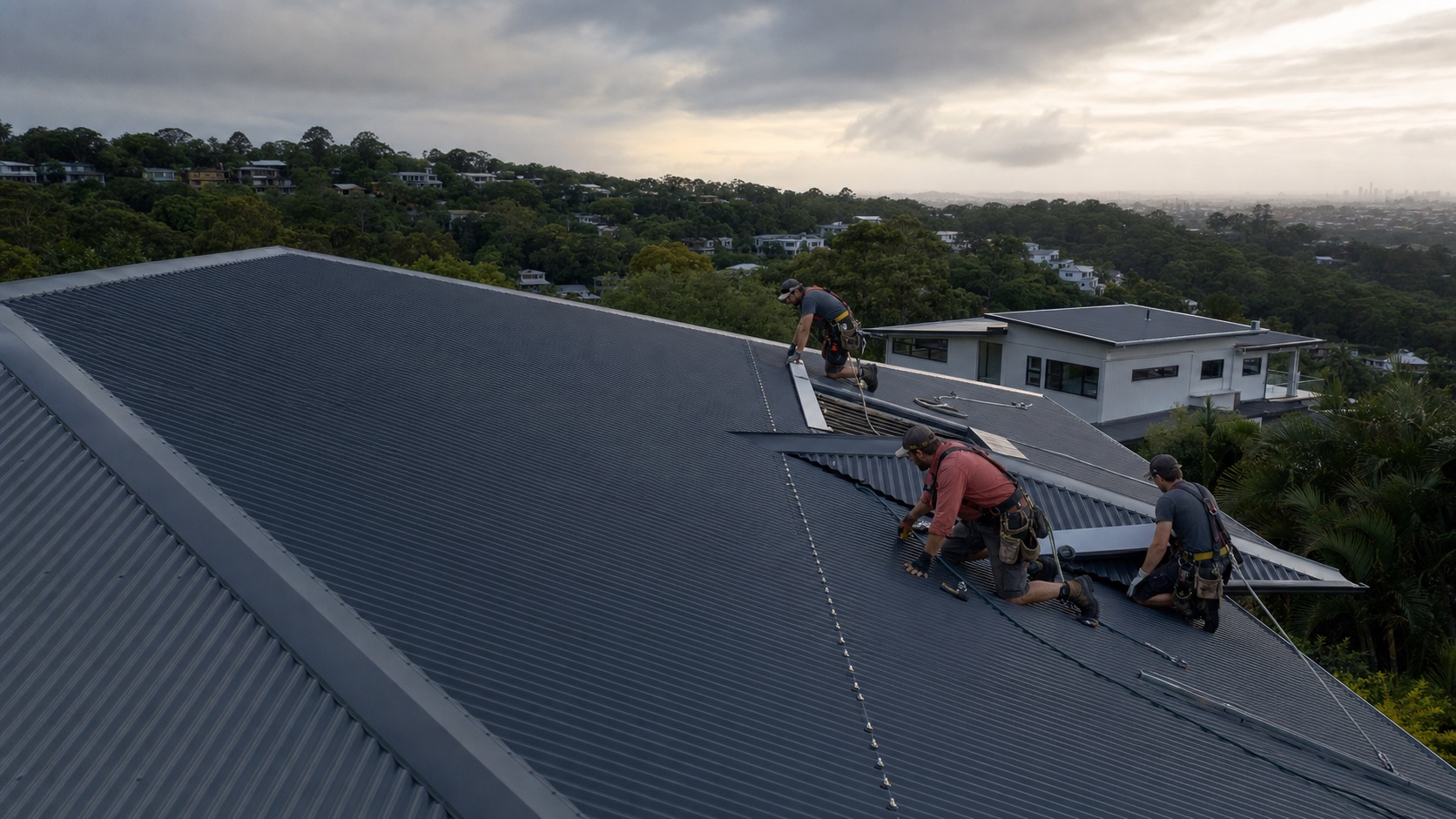 Roofers replacing a dark metal roof on a Brisbane hillside home